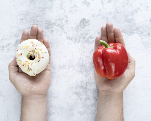 person-choosing-bellpepper-donut-textured-background